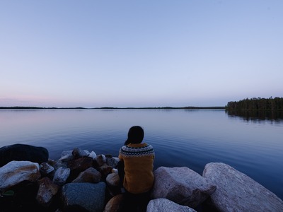 Villapaitaan pukeutunut henkilö öisen järven rannalla.